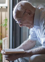 An old man sitting and reading a book