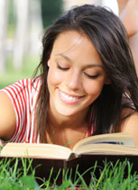 woman lying on grass readding a book